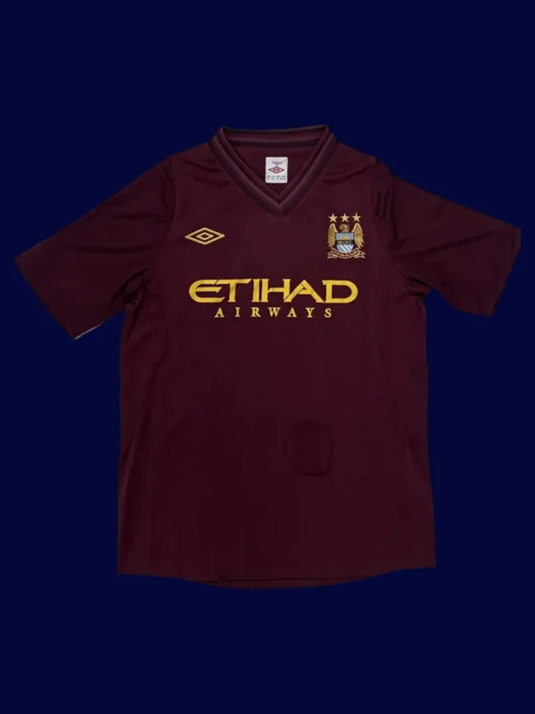 front view of Manchester City away retro jersey (12/13) in dark colors with vintage styling.
