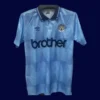 Manchester City Home Blue Retro shirt 1989A - KFCool – Football Jerseys & Soccer Kits Store front view of Manchester City home blue retro shirt (1989) with classic collar.