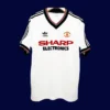 Manchester United Away White Retro Jersey 8283A - KFCool – Football Jerseys & Soccer Kits Store front view of Manchester United away white retro jersey (82/83) with vintage collar and trim.