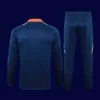 back view of blue Manchester United tracksuit (2025) showing ergonomic back and tapered hem.
