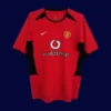 front view of Manchester United home retro jersey (02/04) in red with traditional collar.