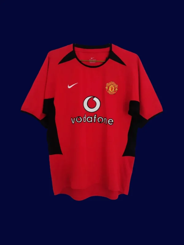 front view of Manchester United home retro jersey (02/04) in red with traditional collar.