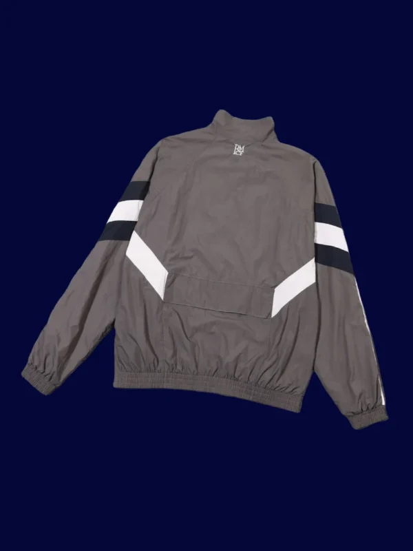 back view of grey windbreaker kit showing ventilation panels and tapered hem (24/25).