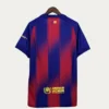Blue and red striped jersey on a hanger, back view, with UNHCR logo near the hem and a small flag patch at the upper back.