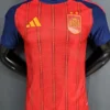 Spain national football team jersey by Adidas: red with blue sleeves, yellow Adidas logo, crest with crown and two stars on the chest.