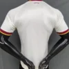 Back view of a white textured athletic jersey on a mannequin, with red and yellow trim on sleeves and collar and a small España logo at the neck.