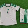 White soccer jersey and shorts with green accents laid on grass; team crest with crescent and two stars and Adidas logo on the chest.