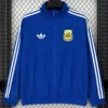 Blue Adidas track jacket with white stripes down sleeves and zip front, displayed against a mesh background; features a white trefoil logo on the left chest and a yellow AFA crest on the right chest.