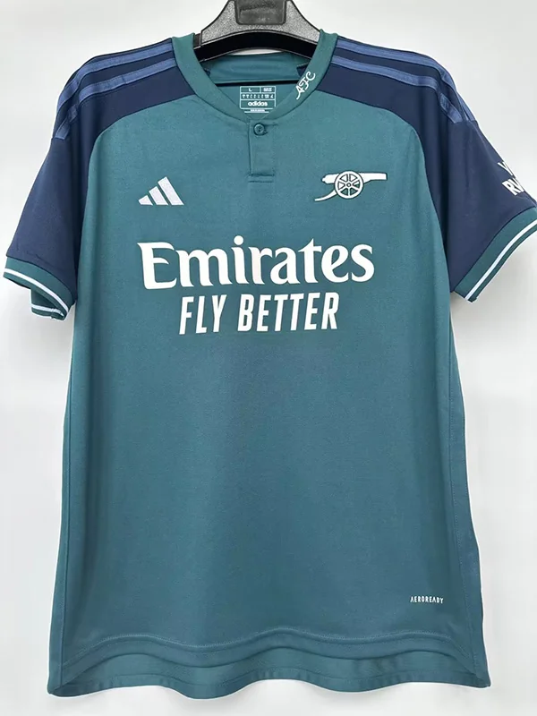 Arsenal 2023/24 Third Jersey Fan Version - Front View Arsenal teal away jersey with Emirates Fly Better sponsor and Adidas logo, hanging on a hanger.