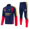 Navy blue training top with red panels, yellow Adidas stripes, and Emirates Fly Better sponsor; matching navy pants with yellow side stripes and red cuffs?