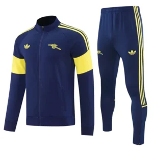 Arsenal 2026/27 Royal Blue Jacket Tracksuit - Front View Navy blue tracksuit with yellow accents: zip-up jacket with yellow shoulder stripes and arm bands, matching pants with side stripes and logos.
