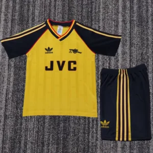 Yellow soccer jersey with navy sleeves, red trim, and JVC sponsor; includes Adidas logos and matching navy shorts with yellow stripes.
