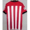 Athletic Bilbao 2011/12 Retro Home Jersey Fan Version - Back View Red soccer jersey with white vertical stripes hanging on a hanger, black cuffs on the sleeves, against a grid backdrop.