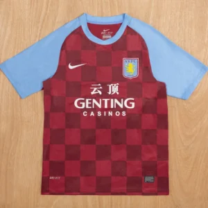 Aston Villa 2011/12 Retro Home Jersey Fan Version - Front View Maroon checkered soccer jersey with light blue sleeves, featuring a crest on the chest and 'GENTING CASINOS' sponsor text in white across the front.