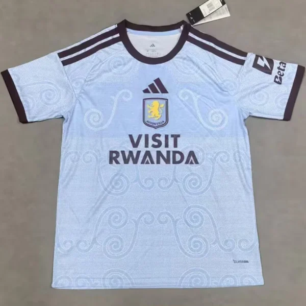 Light blue soccer jersey with dark navy trim, club crest (lion) on chest, Adidas logo, and 'VISIT RWANDA' sponsor on front.