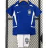 Blue Brazil national team jersey with white accents and crest, paired with white shorts featuring the Brazilian badge, hanging on a hanger in front of a fence.