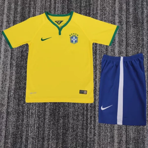 Brazil national soccer jersey in bright yellow with green trim and crest, paired with blue shorts with a white stripe, laid flat on a gray carpet