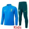 Brazil 2026/27 Green Blue Kids Half Pull Tracksuit - Front View - KFCool – Football Jerseys & Soccer Kits Store Kids' Brazil football training tracksuit: blue top with crest and neon accents, matching dark green pants with yellow Nike logo.
