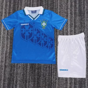 Blue Brazil national football jersey with crest on a white-trimmed collar, paired with white shorts featuring an Umbro logo laid on a textured floor.