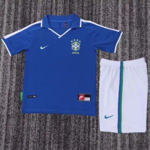 Brazil 1997/98 Retro Away Kids Kit Fan Version - Front View Blue Brazil national team jersey with crest and five stars, paired with white shorts featuring a green stripe and Nike logos, laid flat on a carpet.