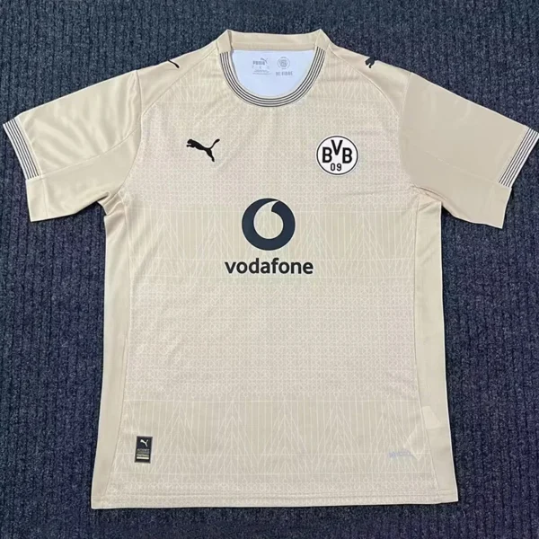 Beige Borussia Dortmund away jersey laid flat, showing BVB 09 crest, Vodafone sponsor, and the Puma logo on the chest.