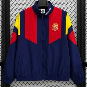 Navy blue jacket with red and yellow panels, front zipper, elastic hem and cuffs; Spain crest on left chest and Adidas logo on collar.