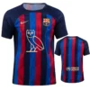 Front-and-back view of a FC Barcelona-style soccer jersey with blue and red vertical stripes, Nike swoosh, club crest, owl emblem, and UNHCR logo on the back panel.