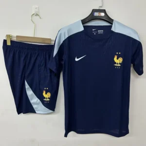 France national team navy jersey and shorts hanging on a rack; rooster crest with FFF and two stars, white Nike swoosh, light blue shoulder panels