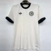 White soccer jersey with black trim, hanging on a hanger; left chest has a circular club crest, right chest has an Adidas logo, and 'AEROREADY' appears near the hem along the bottom right.