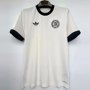 Germany 2024/25 Anniversary White Jersey Fan Version - Front View White soccer jersey with black trim, hanging on a hanger; left chest has a circular club crest, right chest has an Adidas logo, and 'AEROREADY' appears near the hem along the bottom right.