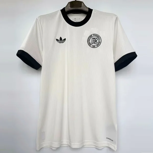 White soccer jersey with black trim, hanging on a hanger; left chest has a circular club crest, right chest has an Adidas logo, and 'AEROREADY' appears near the hem along the bottom right.