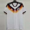 Germany national football team jersey on a hanger, white with black, red, and gold chevron pattern and crest.
