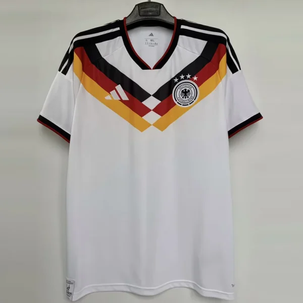 Germany national football team jersey on a hanger, white with black, red, and gold chevron pattern and crest.