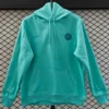 Inter Milan 2025/26 Green Hoody - Front View - KFCool – Football Jerseys & Soccer Kits Store Turquoise hoodie with Inter Milan crest on the chest and a small Nike swoosh, hanging against a diamond-pattern wall.