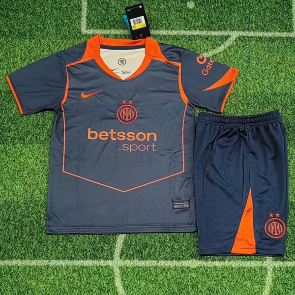 Inter-style dark gray and orange soccer jersey with matching shorts laid on grass field.