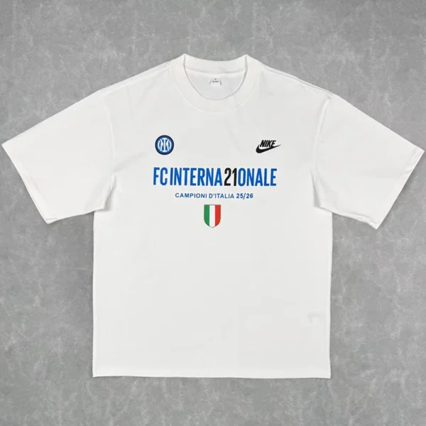 White T-shirt featuring Inter Milan logos: blue 'FC INTERNAZIONALE' text, 'Campioni d'Italia 25/26' line, Nike logo, Inter crest, and a small Italian flag shield.