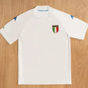 White short-sleeve Italy soccer jersey with tricolor shield crest on the left chest and blue Kappa logos on the sleeves.