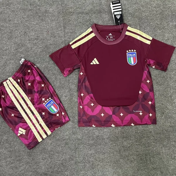 Italy national team maroon training jersey and matching shorts laid flat on a concrete surface with Adidas logo and crest visible.