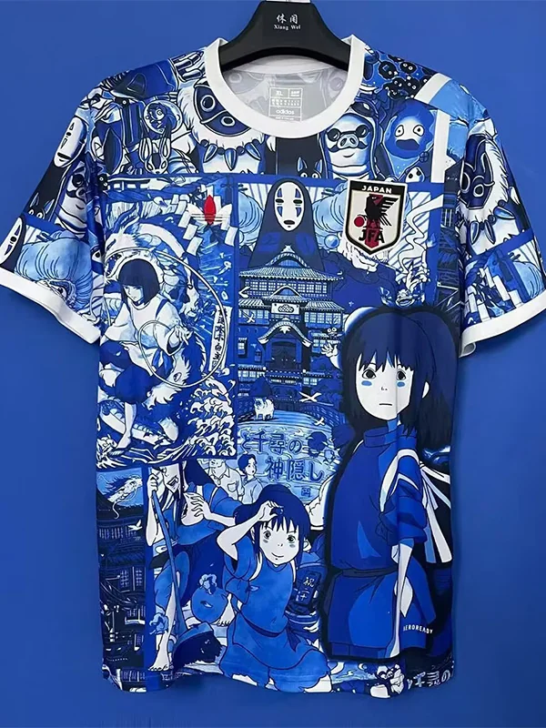 Japan 2025/26 Blue Special Edition Jersey Fan Version - Front View Blue anime-collage T-shirt on a hanger featuring multiple characters and a temple scene, with a Japan JFA patch on the chest.