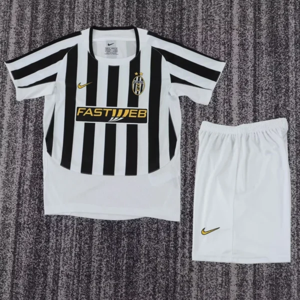 Juventus 2003/04 Retro Home Kids Kit Fan Version - Front View - KFCool – Football Jerseys & Soccer Kits Store Juventus black-and-white striped soccer jersey with sponsor logo and crest, paired with white shorts featuring a gold Nike swoosh.