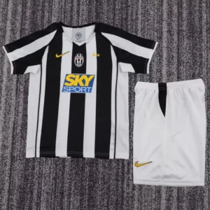 Juventus home jersey with black and white stripes, Sky Sport sponsor, crest, and two gold stars; white shorts beside it.