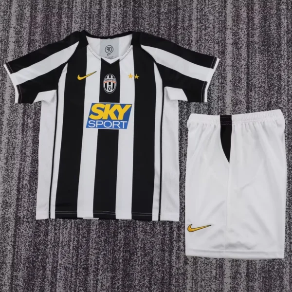 Juventus 2004/05 Retro Home Kids Kit Fan Version - Front View - KFCool – Football Jerseys & Soccer Kits Store Juventus home jersey with black and white stripes, Sky Sport sponsor, crest, and two gold stars; white shorts beside it.