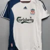 Liverpool FC away jersey hanging on a hanger: white with navy panels, Carlsberg sponsor, Adidas logo, and Liverpool crest visible on the chest