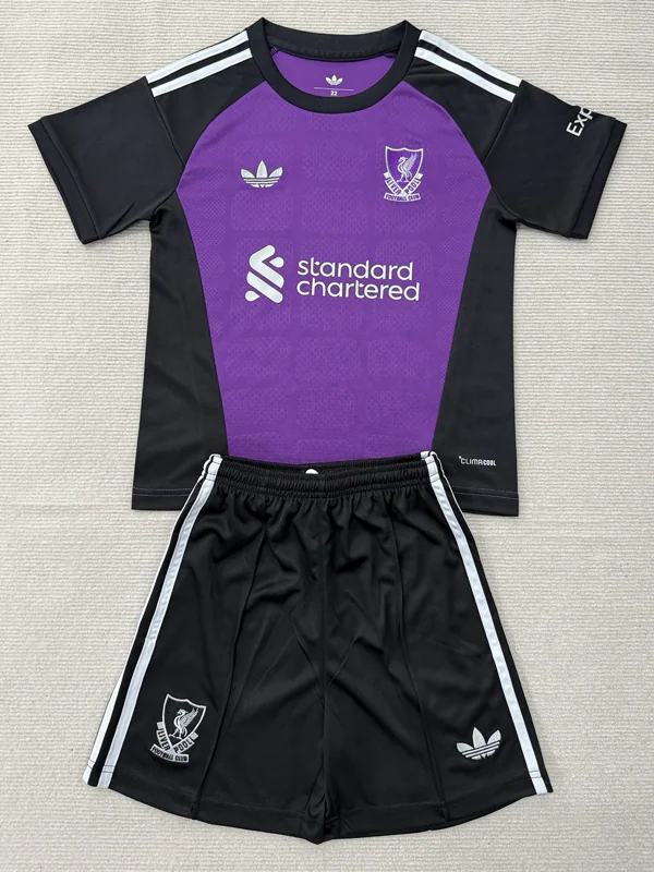 Purple and black soccer jersey with matching black shorts; features sponsor text 'standard chartered' and a club crest on the left chest, plus Adidas stripes on shoulders and shorts.