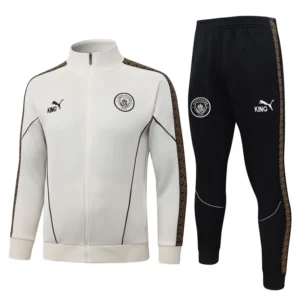 White Manchester City track jacket with a full zipper and matching black track pants; both feature gold-trimmed side stripes, team crest, and Puma King branding.