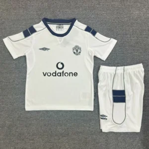 Manchester United 2000/01 Retro Away Kids Kit Fan Version - Front View White Manchester United away kit: jersey with navy trim, Vodafone sponsor, and club crest, paired with white shorts featuring a navy panel.