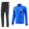 Manchester United 2025/26 Blue Jacket Tracksuit - Front View - KFCool – Football Jerseys & Soccer Kits Store Black Adidas track pants with white side stripes paired with a blue Manchester United track jacket featuring red stitching and the club crest on the chest.