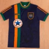 Newcastle United 1997/98 Retro Away Jersey Fan Version - Front View Navy blue Adidas soccer jersey with orange and green vertical stripes, crest on the chest, and a Newcastle Brown Ale round logo an orange ring.