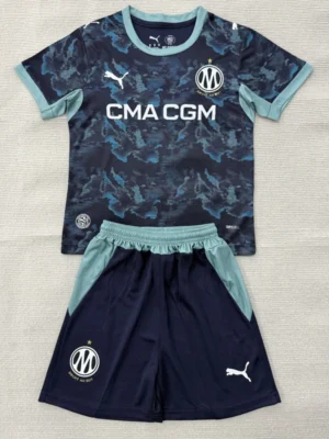 Marseille 2026/27 Away Kids Kit Fan Version - Front View Dark blue camo soccer jersey with light teal trim and matching shorts laid flat, featuring CMA CGM sponsor and club crest.