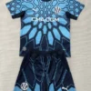 Blue geometric-pattern soccer jersey with matching shorts, Marseille logo, and CMA CGM sponsor text—team kit laid flat for display.